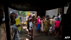 A mental health worker speaks to a small crowd of internally displaced people at a local church in the Delmas district of Port-Au-Prince, Haiti, June 11, 2024.