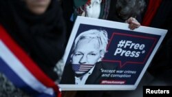 Một người mang hình ông Julian Assange.