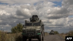 Ukrainian armored military vehicles drive from the direction of the border with Russia, in the Sumy region, on Aug. 13, 2024.