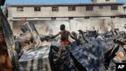 A man looks for salvageable items at a car mechanic shop that was set fire during gang violence in Port-au-Prince, Haiti, March 25, 2024. 