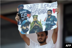 Support system: A fan holds a poster displaying pictures of Pakistan captain Babar Azam in Hyderabad on Friday © Noah SEELAM / AFP
