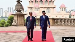 Thủ tướng Trung Quốc Lý Cường (trái) đi cùng Thủ tướng Malaysia Anwar Ibrahim trong cuộc gặp tại Putrajaya, Malaysia, hôm 19/6.