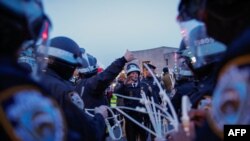 Police officers hold plastic handuffs as they prepare to detain protesters blocking a street near the home of U.S. Senate Majority Leader Chuck Schumer in the Brooklyn borough of New York.