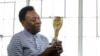 A lenda do futebol, Pelé, segura o troféu do Mundial de 1958 em entrevista em Nova Iorque em abril de 2016