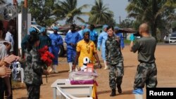 Bệnh nhân Ebola cuối cùng được ghi nhận của Liberia, Beatrice Yardolo (trong trang phục màu vàng) đến một buổi lễ của đơn vị điều trị Ebola của Trung Quốc ở Monrovia, thủ đô của Liberia, nơi cô được điều trị hồi tháng 3 năm 2015. 