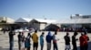 Migrants from Haiti, who returned to the Mexican side of the border to avoid deportation, queue for breakfast at a shelter set by the National Migration Institute (INM) in Ciudad Acuna, Sept. 25, 2021. 