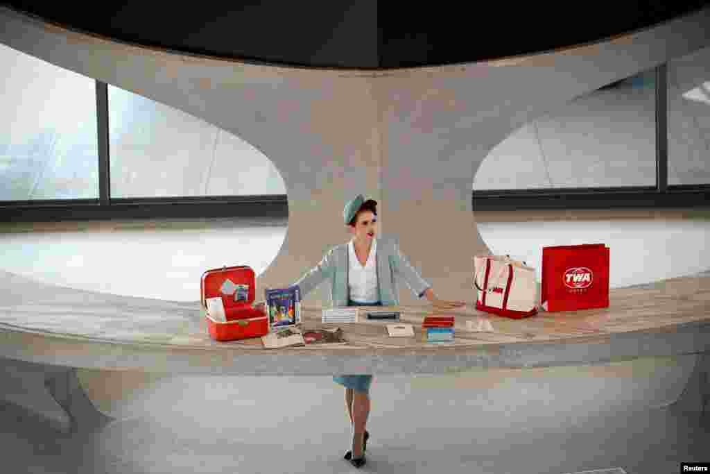 A worker stands behind a reception desk in the main lobby of the TWA Hotel, which is housed inside the former 1962 TWA Flight Center terminal which was designed by architect Eero Saarinen at JFK International Airport in New York, Oct. 2, 2019.