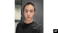 Nan foto Weverse sa a Jin, manm gwoup K-Pop BTS la poze pou yon foto apre li raze tet li anvan li tanmen sevis milite li, Dimanch 11 Desanm, 2022. 