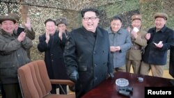 Lãnh đạo Bắc Triều Tiên Kim Jong Un (giữa) mỉm cười khi chỉ đạo một cuộc phóng thử phi đạn đạn đạo trong bức ảnh không đề ngày tháng phát hành bởi Hãng thông tấn chính thức của Bắc Triều Tiên ở Bình Nhưỡng ngày 04/3/2016.