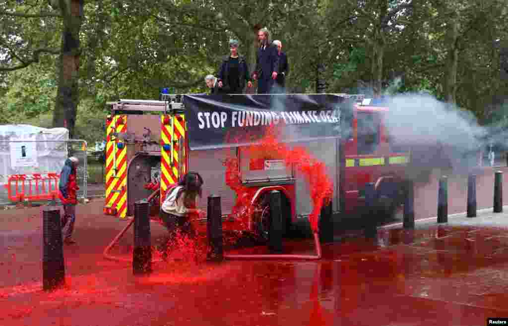 Climate activists from Extinction Rebellion spray fake blood outside the Treasury building in London, to draw attention to global climate breakdown.