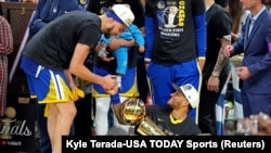 Golden State Warriors - Gary Payton II, com o troféu Larry O'Brien, e Klay Thompson celebram o título de campeões depois de vencerem contra o Boston Celtics no jogo 6 da final da NBA 