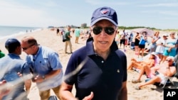 President Joe Biden stops and speaks to members of the media as he walks on the beach with his granddaughter Natalie Biden and daughter Ashley Biden, in Rehoboth Beach, Del., June 20, 2022. 