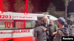 Injured Palestinians are transfered from ambulances to Shuhada al-Aqsa hospital in Deir Al-Balah