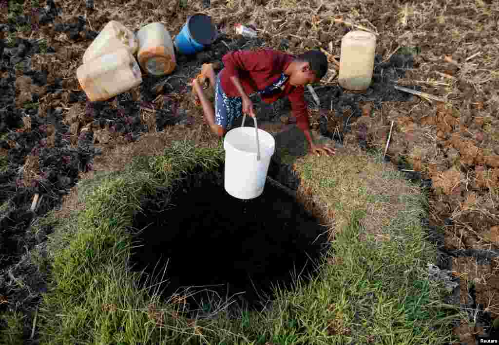 A woman fetches water from a well in Warren Park suburb, Harare, Zimbabwe.