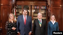 El presidente de México, Andrés Manuel López Obrador, y el de Venezuela, Nicolás Maduro, posan para una foto durante su encuentro en el palacio de Miraflores, en Caracas, el 1 de diciembre de 2018.