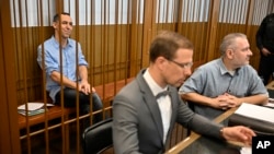 French citizen Laurent Vinatier sits in a cage behind his lawyers at the Zamoskvoretsky District Court in Moscow, Russia, Sept. 16, 2024. 