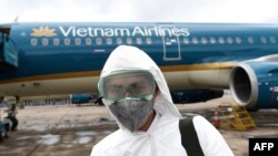 Một nhân viên y tế tham gia khử trùng máy bay của Vietnam Airlines.