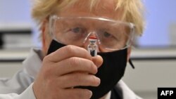 Thủ tướng Anh Boris Johnson chụp ảnh cùng vắc xin của AstraZeneca/Oxford, 30/11/2020. (ảnh tư liệu)