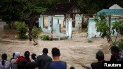 Cư dân đứng trước một khu vực bị ngập lụt ở Kampung Sewuresidential ở Solo, Trung Java, Indonesia, ngày 19/6/2016.