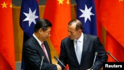 Chủ tịch Trung Quốc Tập Cận Bình bắt tay với Thủ tướng Australia Tony Abbott sau lễ ký kết thỏa thuận thương mại tự do tại Tòa nhà Quốc hội ở thủ đô Canberra, ngày 17/11/2014.