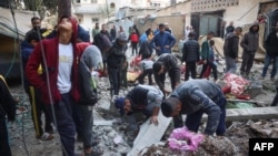 وسطی غزہ میں ایک عمارت پر اسرائیلی فضائی حملے کے بعد فلسطینی ملبے میں دب جانے والوں کو تلاش کر رہے ہیں۔ 22 نومبر 2024 