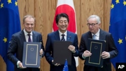 Thủ tướng Nhật Shinzo Abe, giữa, Chủ tịch Hội đồng Liên minh châu Âu Donald Tusk, trái, và Chủ tịch Ủy ban Liên minh châu Âu Jean-Claude Junker cùng chụp ảnh chung sau khi ký kết một hiệp định thương mại tự do hôm 17/7 tại Tokyo, Nhật Bản.