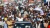 FILE -- Haiti's former President Jean-Bertrand Aristide, left, waves to supporters as he campaigns with presidential candidate Maryse Narcisse, of the Fanmi Lavalas political party, in Port-au-Prince, Haiti, in mid-September. Haiti will hold elections on 