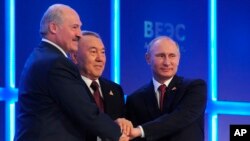 (Từ phải sang) Tổng thống Nga Vladimir Putin, tổng thống Kazahkstan Nursultan Nazarbayev, và tổng thống Belarus Alexander Lukashenko bắt tay sau khi ba nước ký kết thoả thuận thành lập Liên minh Kinh tế Âu Á tại Astana, Kazakhstan, 29/5/2014.