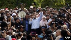 Nhà lãnh đạo đối lập Malaysia Anwar Ibrahim (giữa) nói chuyện với những người ủng hộ ông khi ông ra khỏi tòa án sau khi nghe phán quyềt