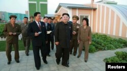 Hãng thông tấn Trung ương cho đăng hình ông Kim Jong Un chống gậy đến thăm một khu dân cư và một học viện, ngày 14/10/2014.