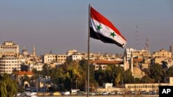 Cờ quốc gia Syria trên một cây cầu trong giờ cao điểm tại Damascus, ngày 28/2/2016.