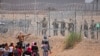 Migrants seeking to enter the United States through a barbed wire fence installed along the Rio Grande are driven away with pepper spray shots by Texas National Guard agents at the border with Ciudad Juarez, Chihuahua State, Mexico, on May 13, 2024. (Phot