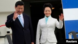 Chinese President Xi Jinping (L) and First Lady Peng Liyuan wave from their plane upon their arrival at Julius Nyerere International Airport in Dar es Salaam March 24, 2013. REUTERS/Thomas Mukoya 