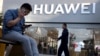 Sử dụng điện thoại thông minh bên ngoài một cửa hiệu Huawei ở Bắc Kinh, 20 tháng Năm, 2019. Hình minh họa.