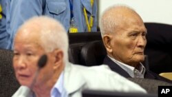 Cựu quốc trưởng Khieu Samphan và Nuon Chea (phải), người đứng đầu công tác tư tưởng của Khmer Đỏ, còn được gọi là Anh Hai, không bày tỏ cảm xúc nào trong lúc Chánh thẩm Nil Nonn tuyên đọc bản án.