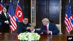 Lãnh tụ Triều Tiên Kim Jong Un (trái) bắt tay với Tổng thống Mỹ Donald Trump tại hội nghị thượng đỉnh ở Singapore.