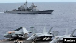 Chiến đấu cơ của Mỹ đậu trên tàu sân bay USS George Washington. Phía sau là tàu tuần dương có tên lửa dẫn đường USS Cowpens trong khu vực Biển Đông, 170 hải lý từ Manila (Ảnh tư liệu).