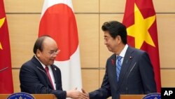 Thủ Tướng Nhật Shinzo Abe (phải) và Thủ Tướng VN Nguyễn Xuân Phúc bắt tay sau cuộc họp báo chung tại văn phòng Thủ Tướng Abe ở Tokyo hôm 8/10/2018. (AP Photo/Eugene Hoshiko, Pool) 