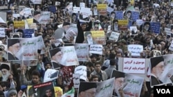 Manifestan ki kenbe nan men yo foto lidè siprèm Ayatollah Ali Khamenei nan yon priyè vandredi nan Tehran kòm yon repons a pwotestasyon antigouvènmantal ki te fè pi bonè nan semèn 28 fev. 2011 (AP Photo/Vahid Salemi)