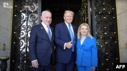 This still image taken from an Israeli Government Press Office video shows Israeli Prime Minister Benjamin Netanyahu (L) and his wife Sara (R) being welcomed by former US President Donald Trump at the Mar-a-Lago Club in West Palm Beach, Florida, on July 2