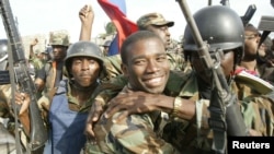 aitian National Revolutionary Liberation Front Commander-in-Chief, Guy Philippe, hugs other soldiers from the 