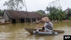 Một dân làng chèo xuồng giữa nước lụt.