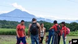 Migrants pause on the shoulder of a road on the outskirts of Tapachula, Chiapas state, Mexico, Nov. 20, 2024, during their journey to the U.S. border.