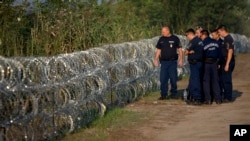 Cảnh sát Hungary kiểm tra một hàng rào thép gai dọc biên giới với Serbia, ngày 29/8/2015.