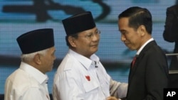 Hai ứng cử viên tổng thống Indonesia Joko Widodo (phải) và Prabowo Subianto (giữa) chào nhau trong cuộc tranh luận đầu tiên trên đài truyền hình, 9/6/14