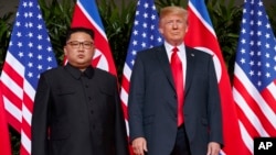 Tổng thống Mỹ Donald Trump (phải) hội kiến lãnh tụ Triều Tiên Kim Jong Un trên Đảo Sentosa, ở Singapore, ngày 12 tháng 6, 2018.