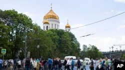 Russian Orthodox believers cross the road to line up to kiss the relics of Saint Nicholas that were brought from an Italian church where they have lain for 930 years, in the Christ the Savior Cathedral in Moscow, Russia. The photo was taken on May 26, 201