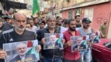 People carry pictures of slain Hamas political leader Ismail Haniyeh during a march to condemn his killing, in the Palestinian refugee camp of Ain al-Hilweh, near the southern Lebanese city of Sidon on July 31, 2024.