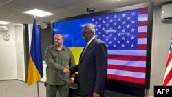 Ukrainian Defence Minister Rustem Umerov (L) greets United States Secretary of Defense Lloyd Austin prior to their talks in Kyiv on November 20, 2023. (Photo by W.G. DUNLOP / POOL / AFP)